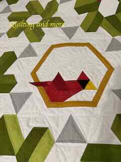 A red cardinal sits on a gold frame.